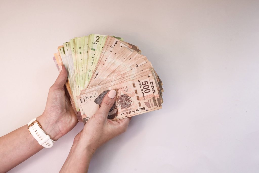 Manos sosteniendo billetes después de recibir préstamo o seiem becas