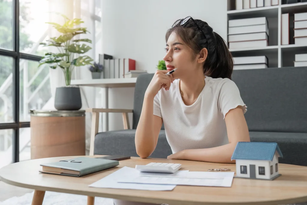 Mujer pensando en nuevos emprendimientos para comprar su casa.