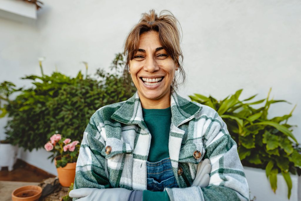 Mujer mexicana en su jardín feliz por su bienestar económico.