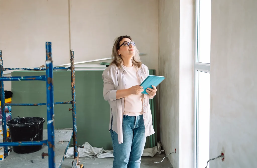 Persona evaluando un espacio del hogar antes de iniciar una remodelación, representando la planificación financiera y organización previa para solicitar un crédito.