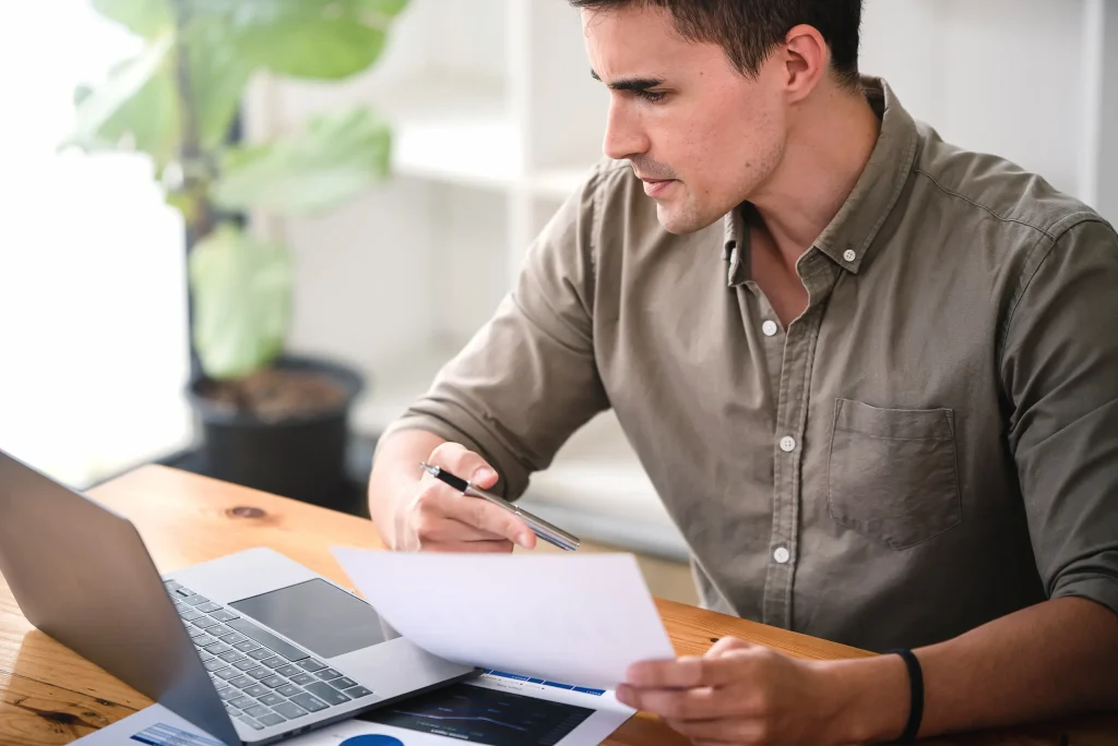Joven revisando documentos para solicitar un préstamo GEM